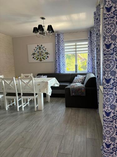 a living room with a couch and a table and chairs at Witómë Kaszubskie Siedlisko in Załakowo