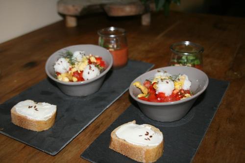 Cocon de Verdure avec piscine chambre lit king-size 2m في Lusignan-Petit: طاولة مع ثلاثة أطباق من الطعام والخبز