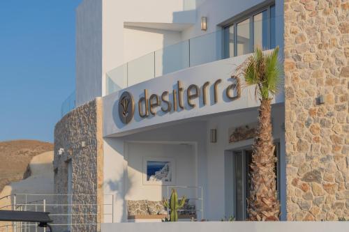 a sign on the side of a building with a palm tree at Desiterra Resort & Spa in Fira
