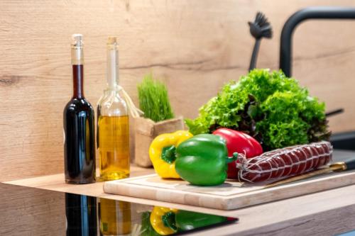 a bunch of vegetables on a cutting board next to a bottle of wine at Ferienwohnung Freia im historischen Gulfhof in Krummhörn