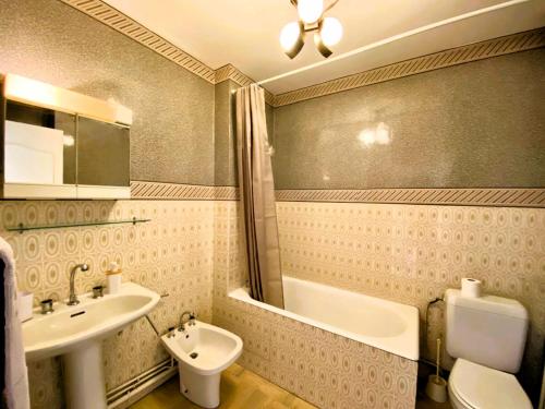 une salle de bain avec un lavabo, une baignoire et des toilettes dans l'établissement Le Petit Foch - Face a la plage, à Les Sables-dʼOlonne