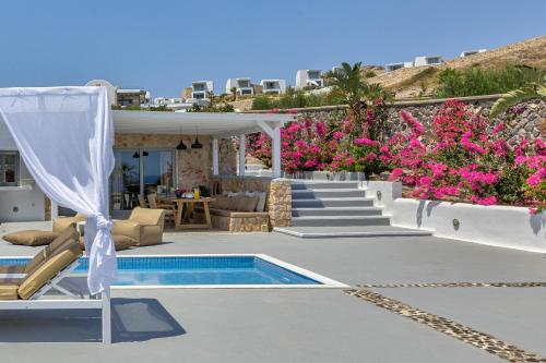 a resort with a swimming pool and pink flowers at Desiterra Resort & Spa in Fira
