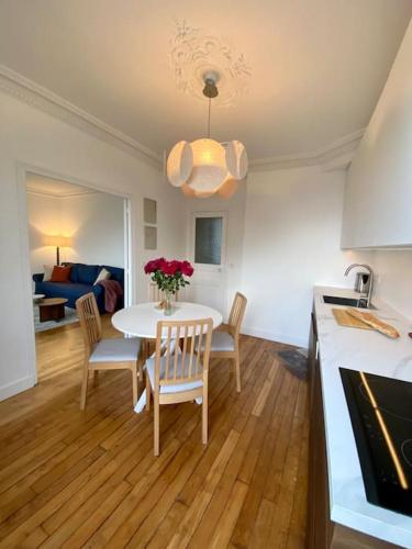 une cuisine et un salon avec une table et des chaises dans l'établissement Onlangs gerenoveerd appartement Vincennes Parijs, à Vincennes