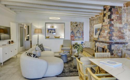 a living room with white furniture and a fireplace at Desiterra Resort & Spa in Fira