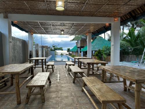 a patio with picnic tables and a swimming pool at Oktowaves hotel in Nasugbu