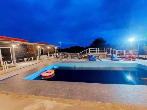 a swimming pool at night with aperatureverningfficientfficientfficientfficientfficient at แม่ให้ โฮมสเตย์ in Ban Tha Rawaek (1)