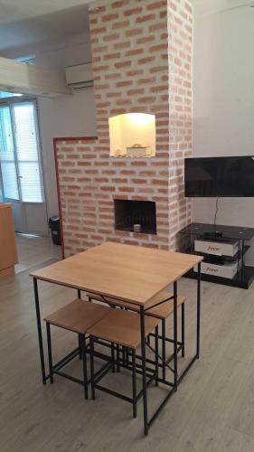 - une table et des chaises devant une cheminée en briques dans l'établissement Appartement centre ville cannes, à Cannes