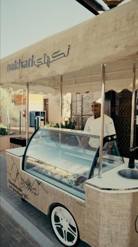 a man is standing next to a hot tub at Cloud 7 Residence AlUla in AlUla