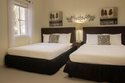 a bedroom with two beds and a window at Ocean Villa Guam in Tamuning