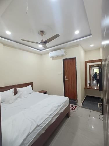 Un dormitorio con una cama y un ventilador de techo. en Vakratunda Home Stay, en Ujjain