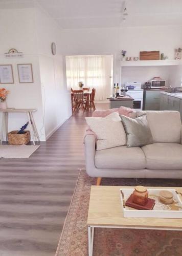 a living room with a couch and a table at Willows Cottage on Anzac in Stanthorpe
