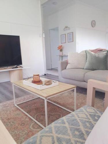 a living room with a couch and a coffee table at Willows Cottage on Anzac in Stanthorpe