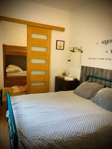 - une chambre avec un lit et une porte en bois dans l'établissement Votre pied à terre en plein coeur du Touquet, à Le Touquet-Paris-Plage