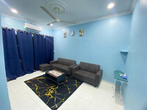 a living room with a couch and a blue wall at VJ Homestay in Jasin