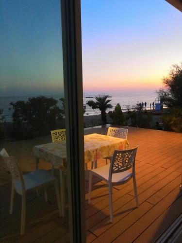 a table and chairs on a deck with a view of the ocean at "Le chic" sulla duna fronte mare in Follonica