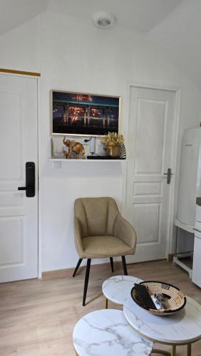 a living room with a chair and two tables at La Perle Rare in Massy