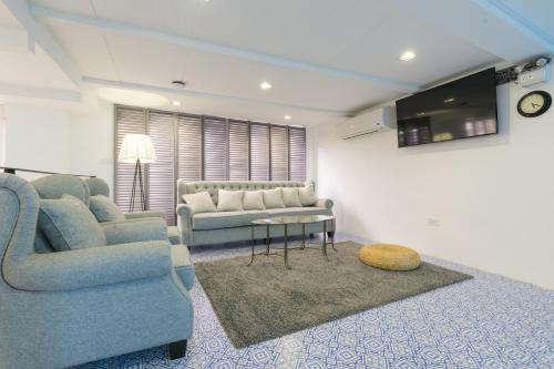 a living room with a couch and a table at White Ivory Bed And Breakfast in Bangkok