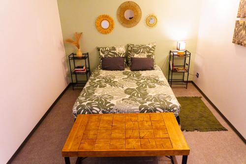 a bedroom with a bed and a wooden coffee table at T3 A l'Ombre des Palmiers - Terrasse Jardin & Barbecue - Proche Aéroport in Sainte-Marie