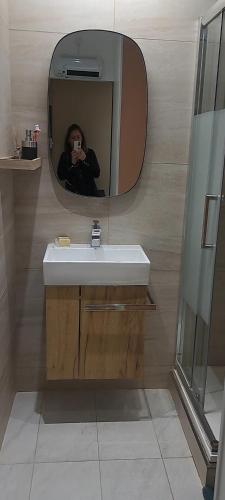 une personne prenant une photo d'un lavabo dans une salle de bains dans l'établissement Studio charmant Cap d'Agde, au Cap d'Agde