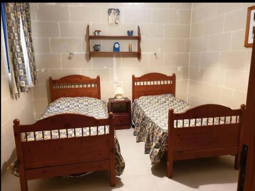 a room with two beds and a table at An excellent getaway choice, in the midst of Qbajjar and Marsalforn Bay! in Żebbuġ