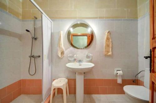 Un baño con lavabo, ducha y espejo. en An excellent getaway choice, in the midst of Qbajjar and Marsalforn Bay!, en Żebbuġ