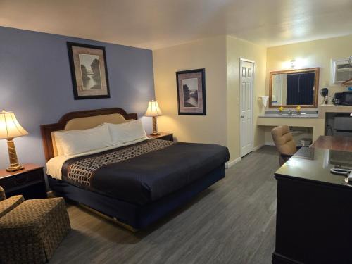 a hotel room with a bed and a desk at Rodeway Inn & Suites Blythe I-10 in Blythe