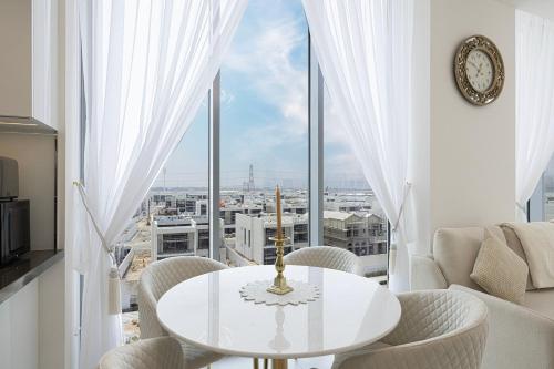 a white table and chairs in a room with a large window at Luxury Apt Burj Khalifa, Sunset and Lagoon view in Dubai