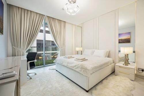 a bedroom with a bed and a desk and a window at Luxury Apt Burj Khalifa, Sunset and Lagoon view in Dubai