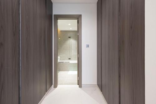 a hallway with wood paneled walls and a bathroom at Luxury Apt Burj Khalifa, Sunset and Lagoon view in Dubai