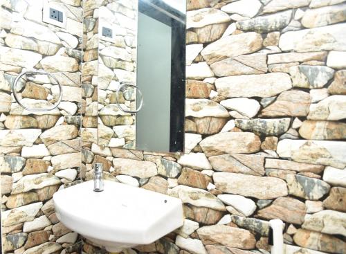 a bathroom with a sink and a stone wall at Valerys Nest Bogmalo - Private villa near the beach and Dabolim airport in Bogmolo