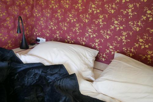 a bedroom with a bed with gold flowers on the wall at Hoeve Zorglust, salonwagen voor 2 personen met extra slaapkamerhuisje voor 2 - 3 kinderen in Koudekerke
