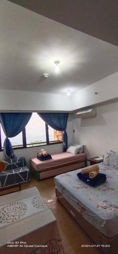 a bedroom with two beds and a large window at Splendido Tagaytay Taal Lake Staycation Free Parking Netflix No Free Pool in Tagaytay