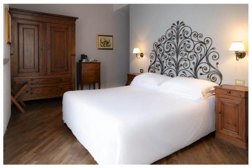 a bedroom with a large white bed with a large headboard at Albergo Ristorante Il Verbano in Stresa