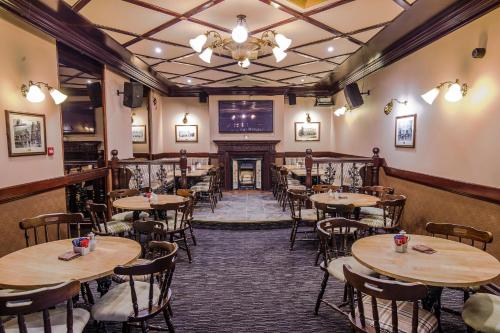 a restaurant with tables and chairs and a fireplace at Globe Inn in Tamworth