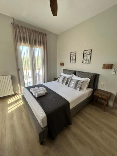 a bedroom with a large bed and a window at VENTO villa neriana in Khainderianá