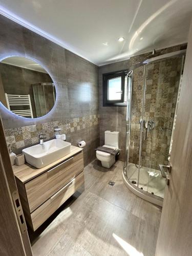 a bathroom with a sink and a shower and a toilet at VENTO villa neriana in Khainderianá