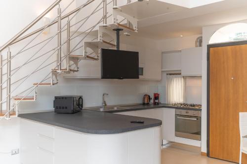 a kitchen with white cabinets and a counter top at LA CASA DI SASA' in Maiori