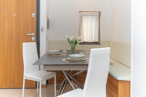 a dining room with a table and white chairs at LA CASA DI SASA' in Maiori