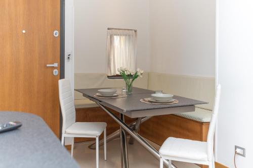 a dining room table with two chairs and a table with flowers on it at LA CASA DI SASA' in Maiori