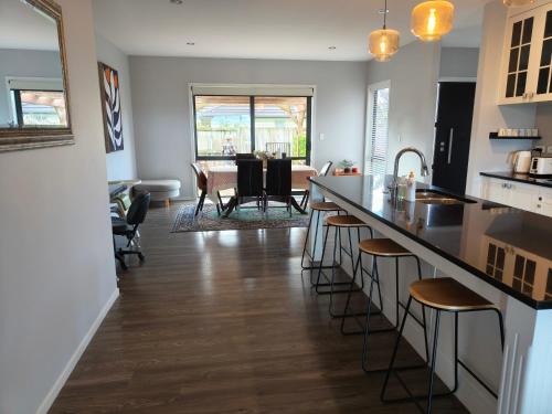 a kitchen and living room with a counter and chairs at peaceful gully view home -4 bedrooms in Hamilton