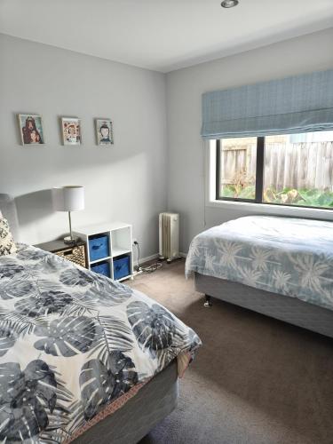 a bedroom with two beds and a window at peaceful gully view home -4 bedrooms in Hamilton