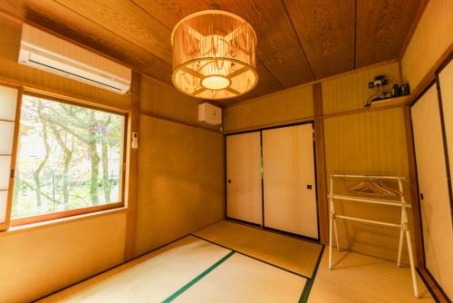 a room with a hallway with a chandelier at 4月リニューアルOpen! 全室エアコン完備! Cottage あかいやねｰ The Red Roof Cottage YamanakaKoｰ in Yamanakako