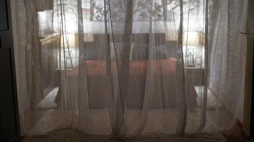 a window with white curtains in a room at Villa Salviati in Prato