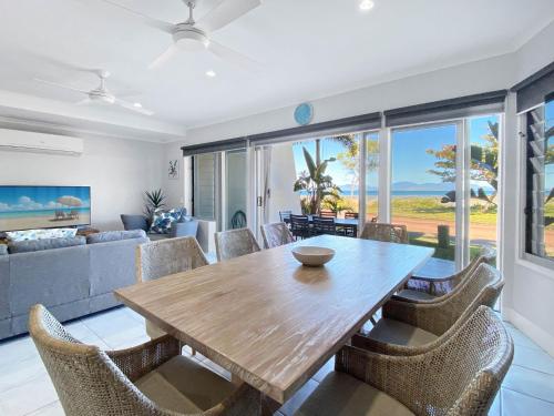 a living room with a wooden table and chairs at Magnetic Docks Townhouse 5 in Nelly Bay