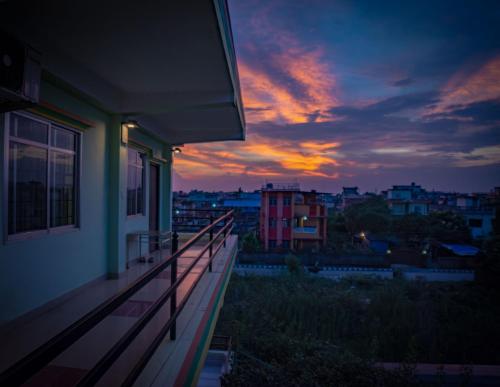 a balcony of a house with a sunset in the background at Galaxy Guest House in Bhairāhawā