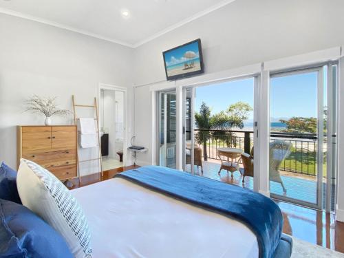 a bedroom with a bed and a view of the ocean at Magnetic Docks Townhouse 5 in Nelly Bay