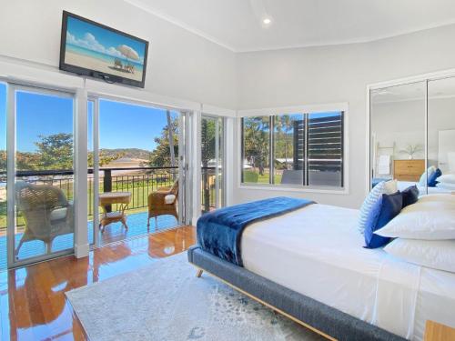 a bedroom with a large bed and a balcony at Magnetic Docks Townhouse 5 in Nelly Bay