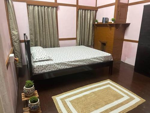 a bedroom with a bed in a room with a fireplace at Heritage House Shillong in Shillong