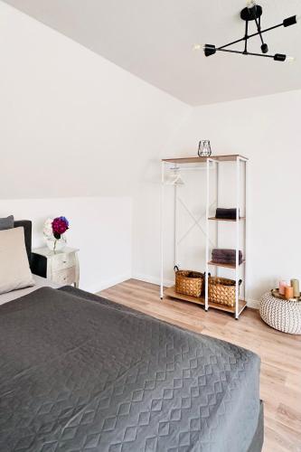 a bedroom with a bed and a white wall at Die Stader Maisonette in Stade
