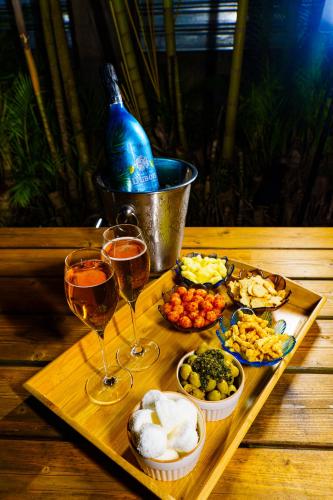 a tray of food and two glasses of wine at T3 A l'Ombre des Palmiers - Terrasse Jardin & Barbecue - Proche Aéroport in Sainte-Marie